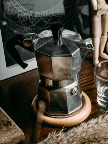 silver and black coffee maker on brown wooden table